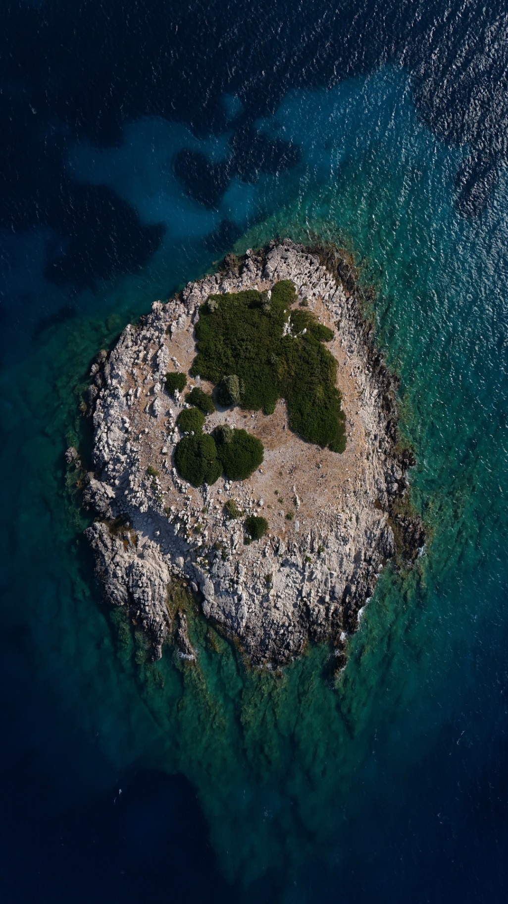Isolotto roccioso nel mare cristallino vista zenitale