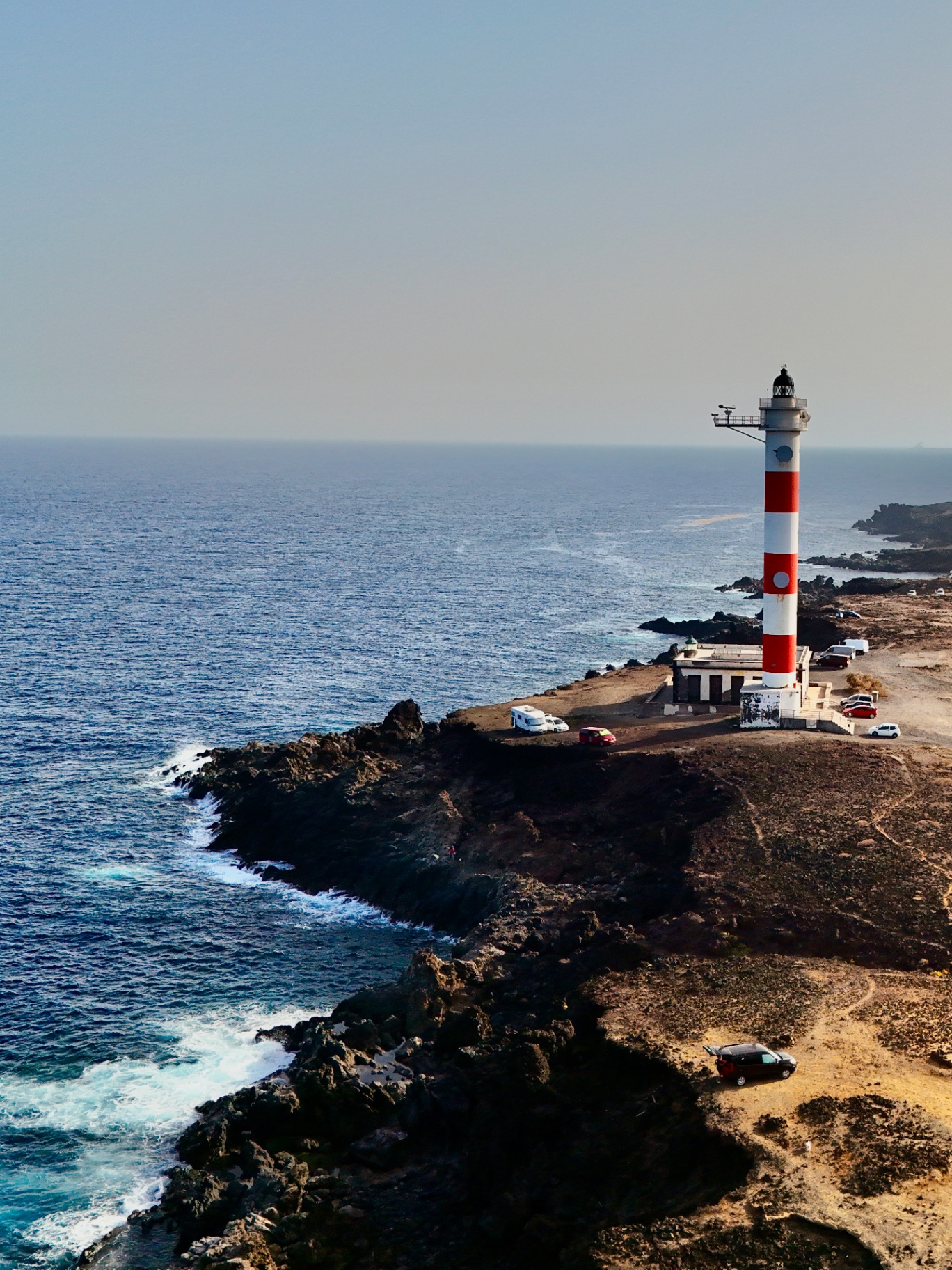 Faro a strisce rosse e bianche sulla costa rocciosa di Tenerife